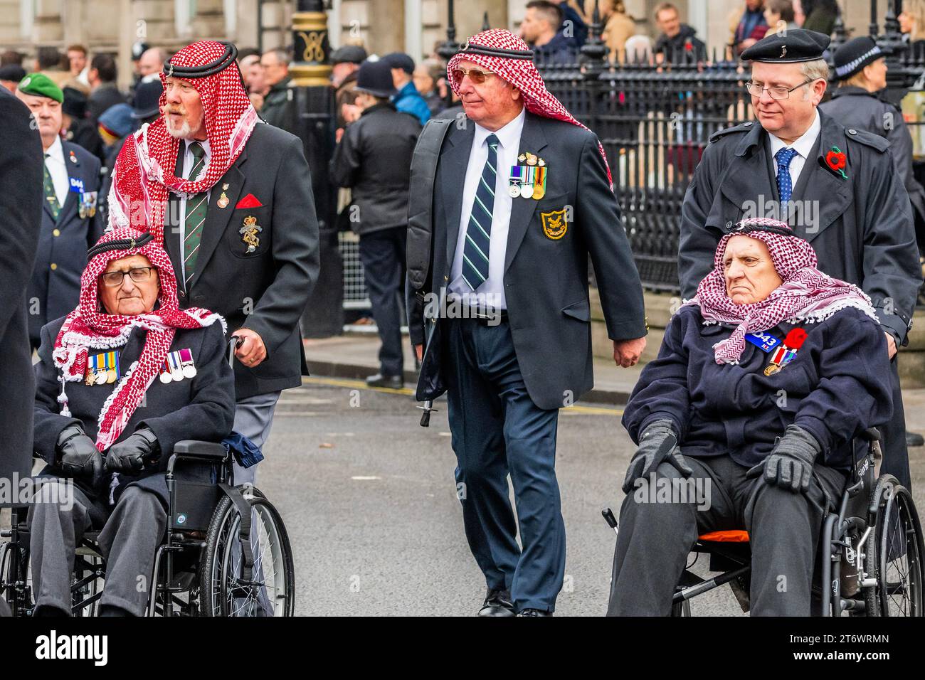 Londra, Regno Unito. 12 novembre 2023. I veterani in copricapo arabo (molti su scooter da mobilità o in sedia a rotelle) e altri gruppi marciano davanti al Cenotafio e fuori da Whitehall - Un servizio domenicale di ricordo piovoso, posa di ghirlande e passarono davanti al Cenotafio, Whitehall, Londra. Crediti: Guy Bell/Alamy Live News Foto Stock