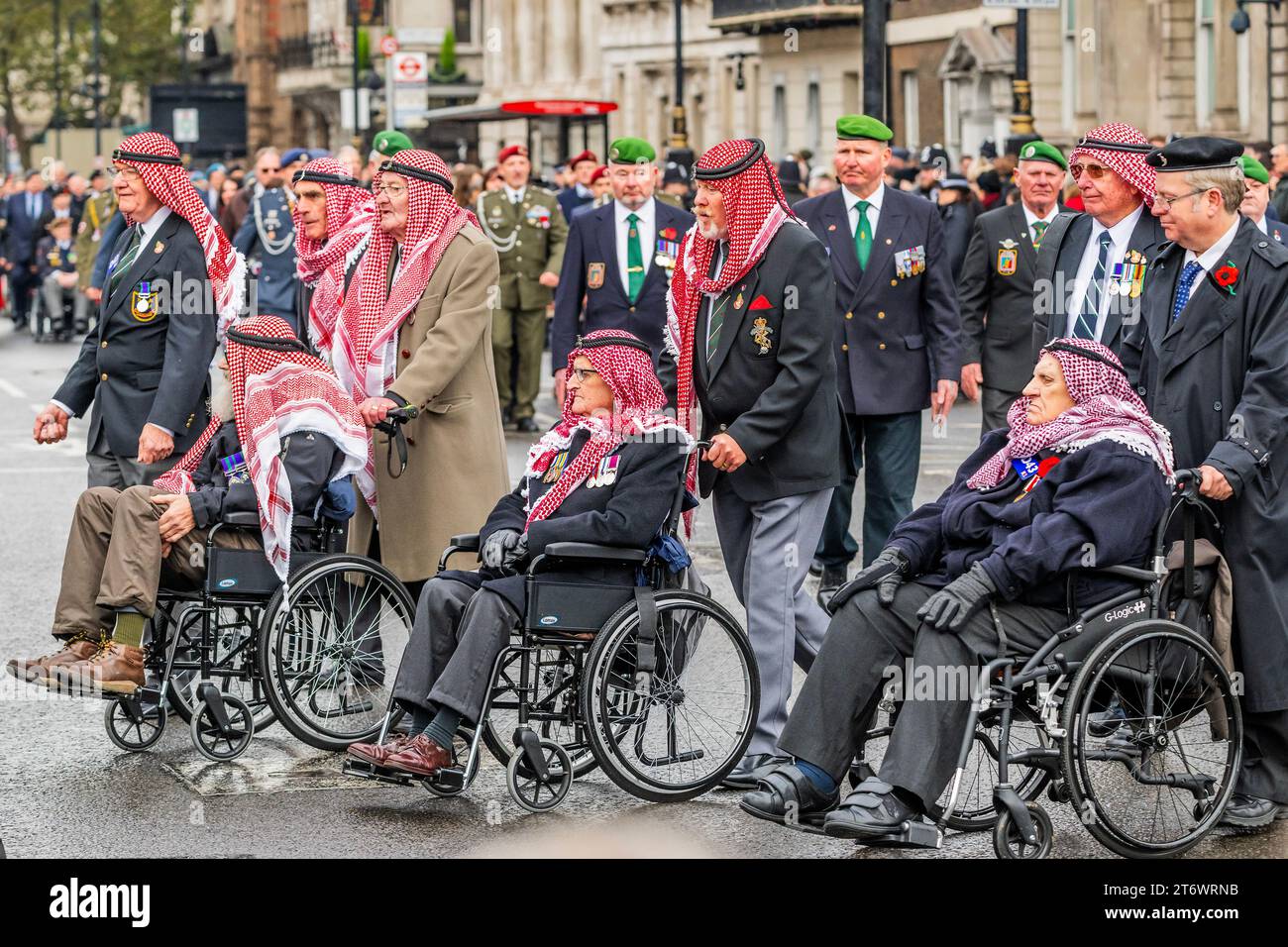 Londra, Regno Unito. 12 novembre 2023. I veterani in copricapo arabo (molti su scooter da mobilità o in sedia a rotelle) e altri gruppi marciano davanti al Cenotafio e fuori da Whitehall - Un servizio domenicale di ricordo piovoso, posa di ghirlande e passarono davanti al Cenotafio, Whitehall, Londra. Crediti: Guy Bell/Alamy Live News Foto Stock