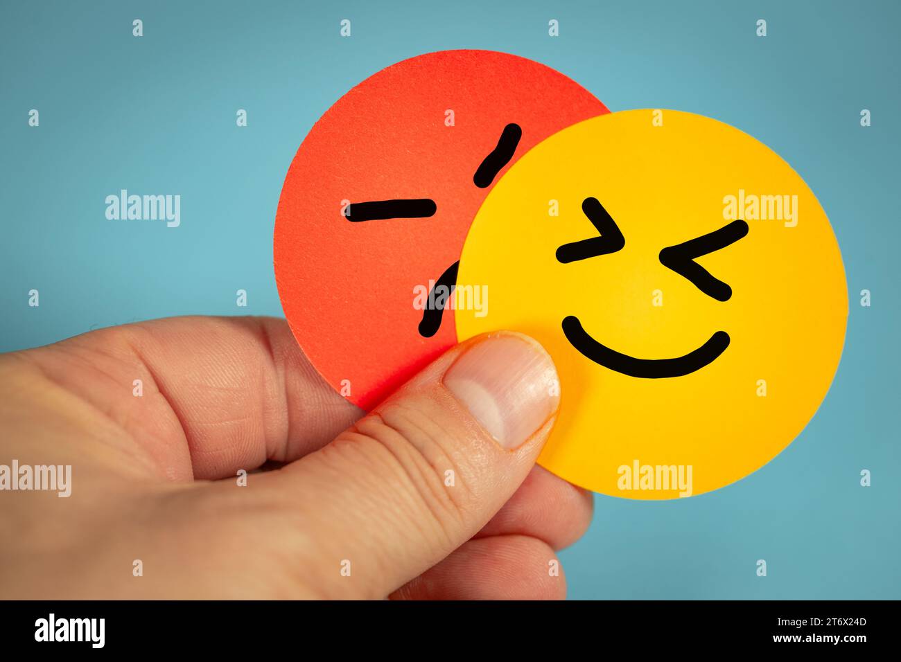 Volto arrabbiato e felice, emozioni umane, espressioni facciali dipinte a mano, atteggiamento positivo ed espressione facciale arrabbiata, cambiamento di emozione, sfondo blu Foto Stock