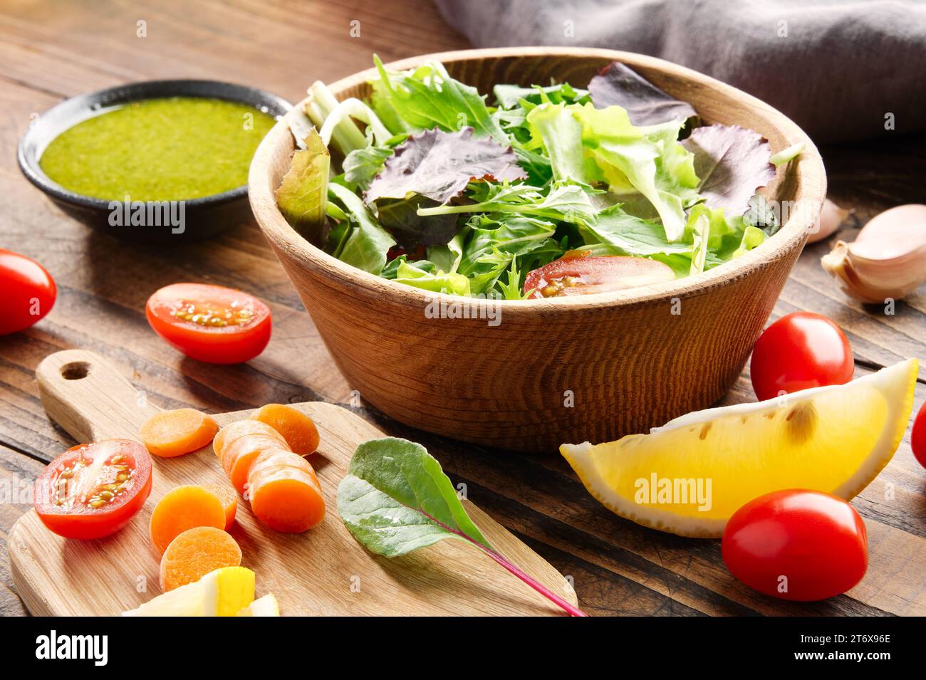 Insalata di verdure in ciotola e ingredienti su tavola di legno. Foto Stock