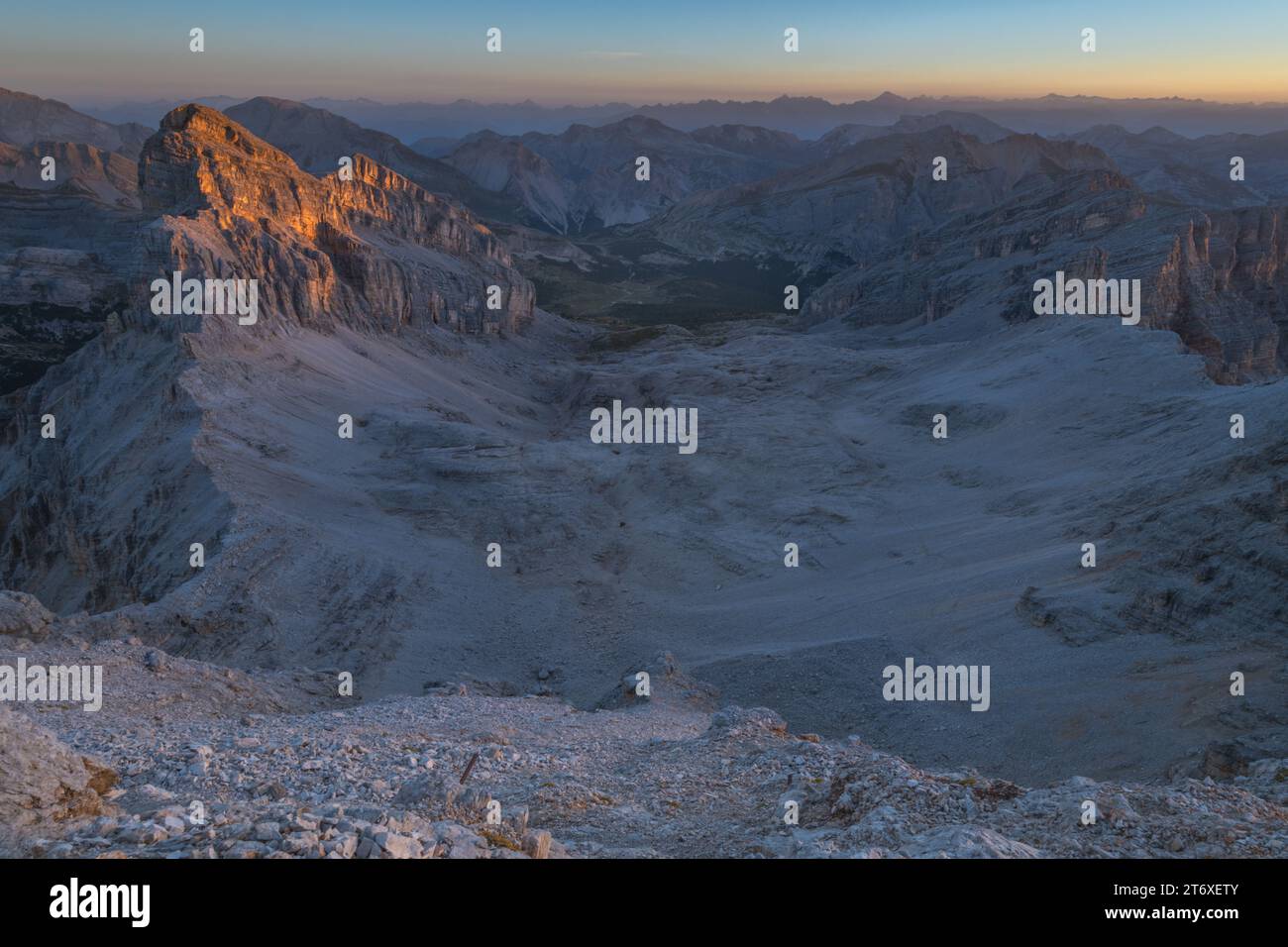 Alba alpina nelle Dolomiti, vista del Vallon bianco nel parco Fanes con pendenze rocciose di butte e di ghiaia. Foto Stock