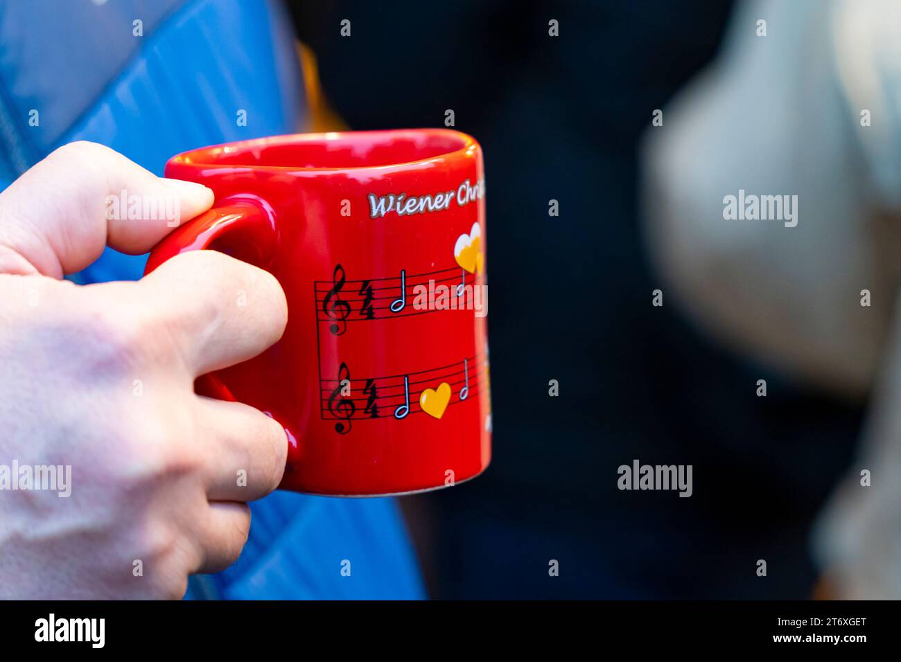 Mano che tiene una tazza di natale rossa in un mercatino di Natale a Vienna, Austria, il 3 dicembre. 2022: Foto Stock