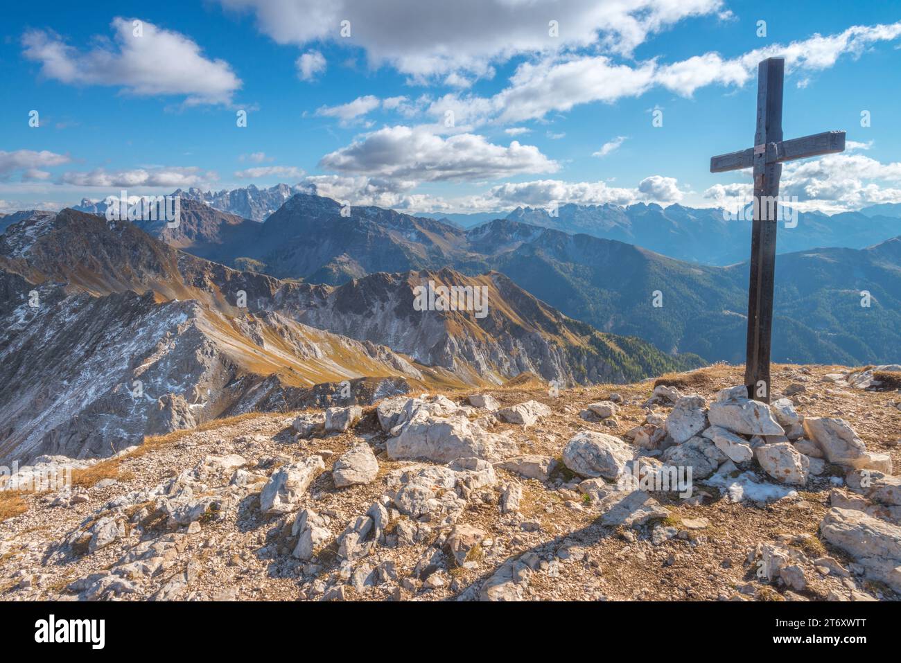 Croce di montagna, croce in cima con vista sullo sfondo delle catene montuose delle Dolomiti italiane. Escursioni autunnali su una strada a dorso di cavallino. Foto Stock