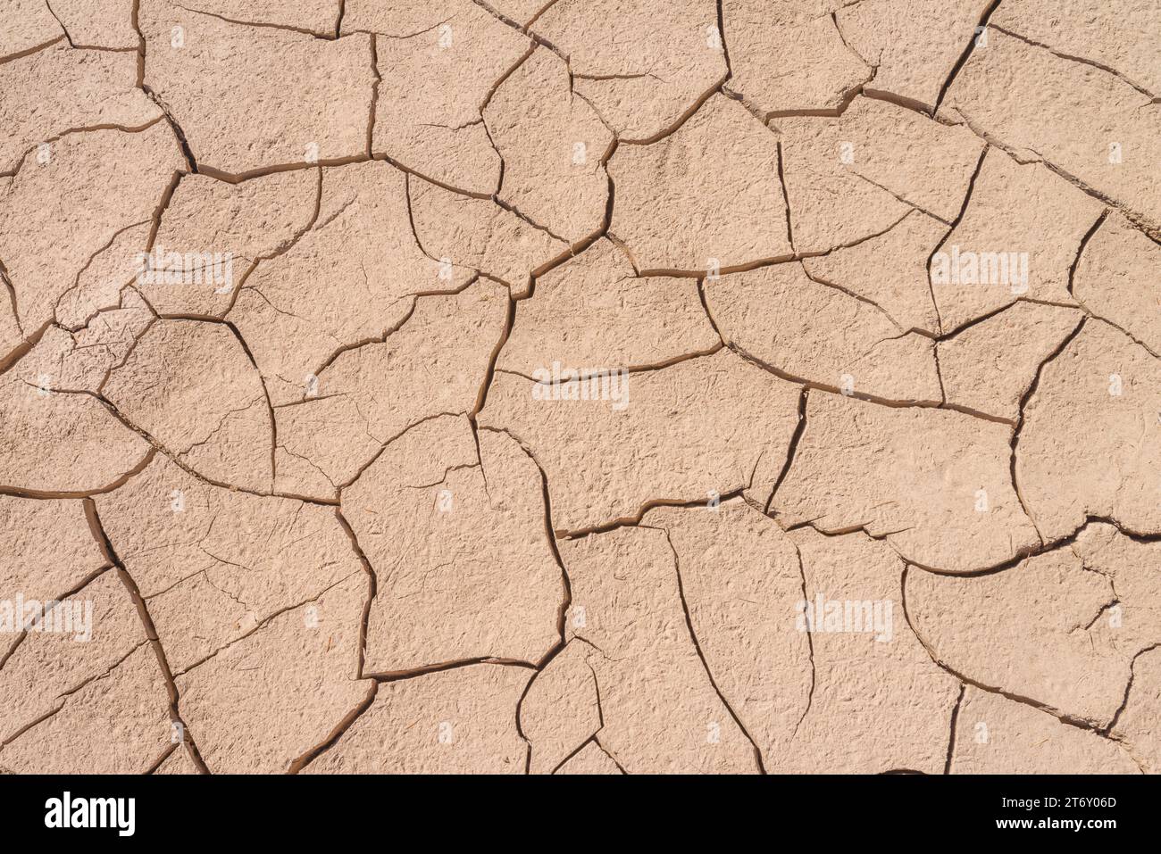 Grave siccità che produce terreno asciutto e arenato, con fango secco incrinato e forme artistiche nella terra sabbiosa. Cambiamento climatico in montagna. Foto Stock