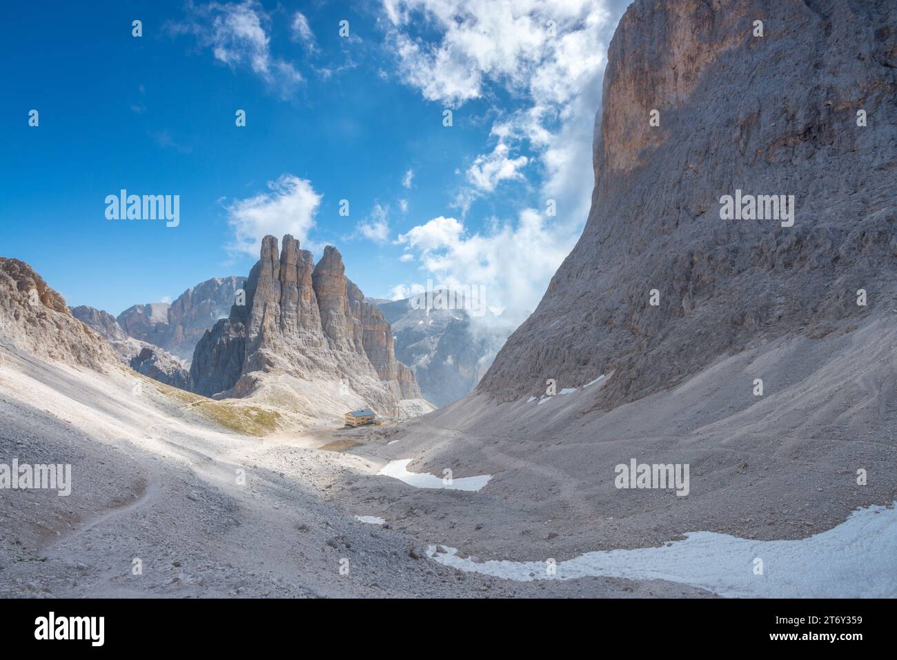 Maestose torri del Vajolet nel gruppo del Catinaccio delle Dolomiti, con rifugio Re Alberto e una ripida valle di ghiaia scolpita Foto Stock