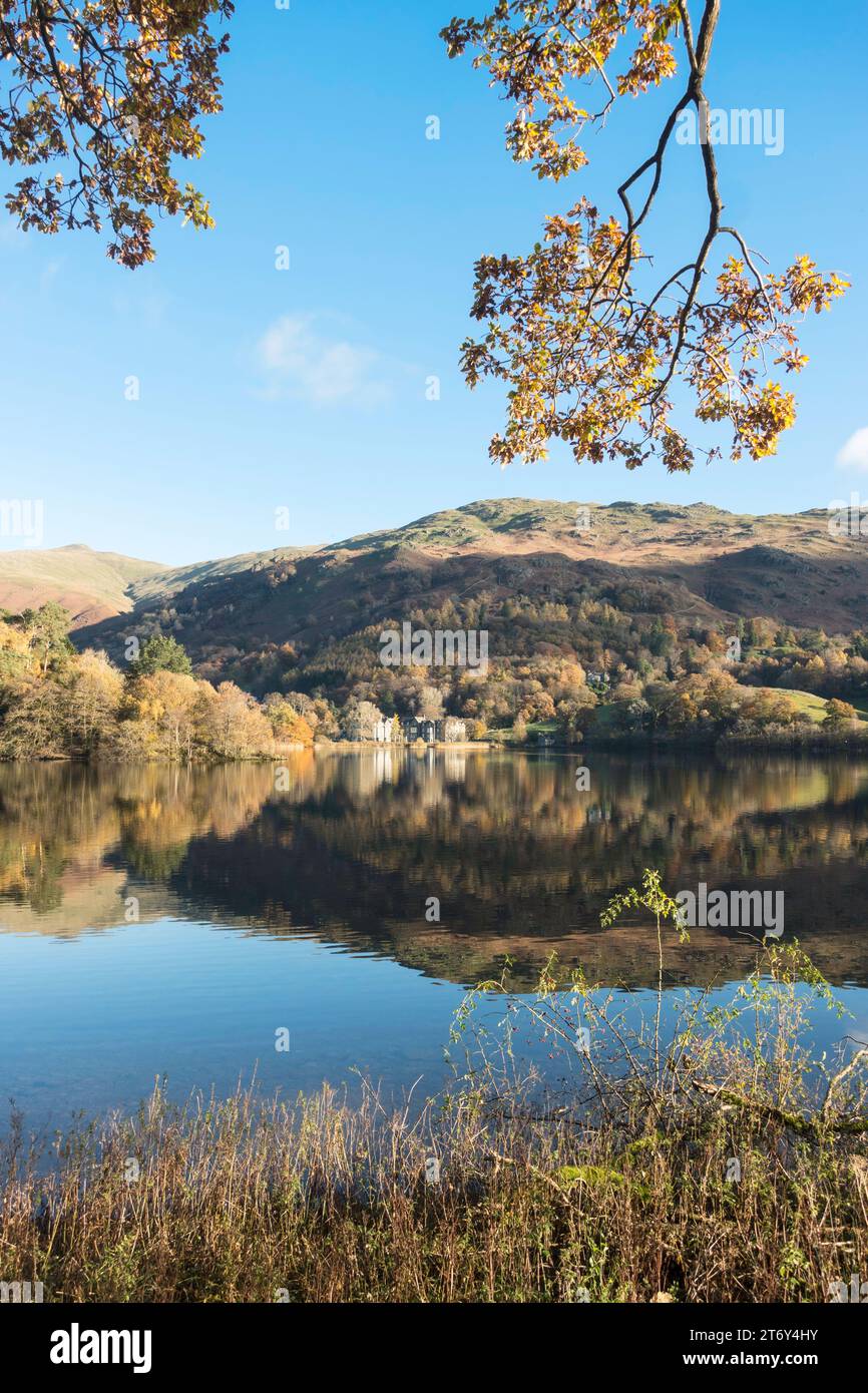 Vista autunnale del lago Grasmere, con le colline che si riflettono nell'acqua, Cumbria, Inghilterra, Regno Unito Foto Stock