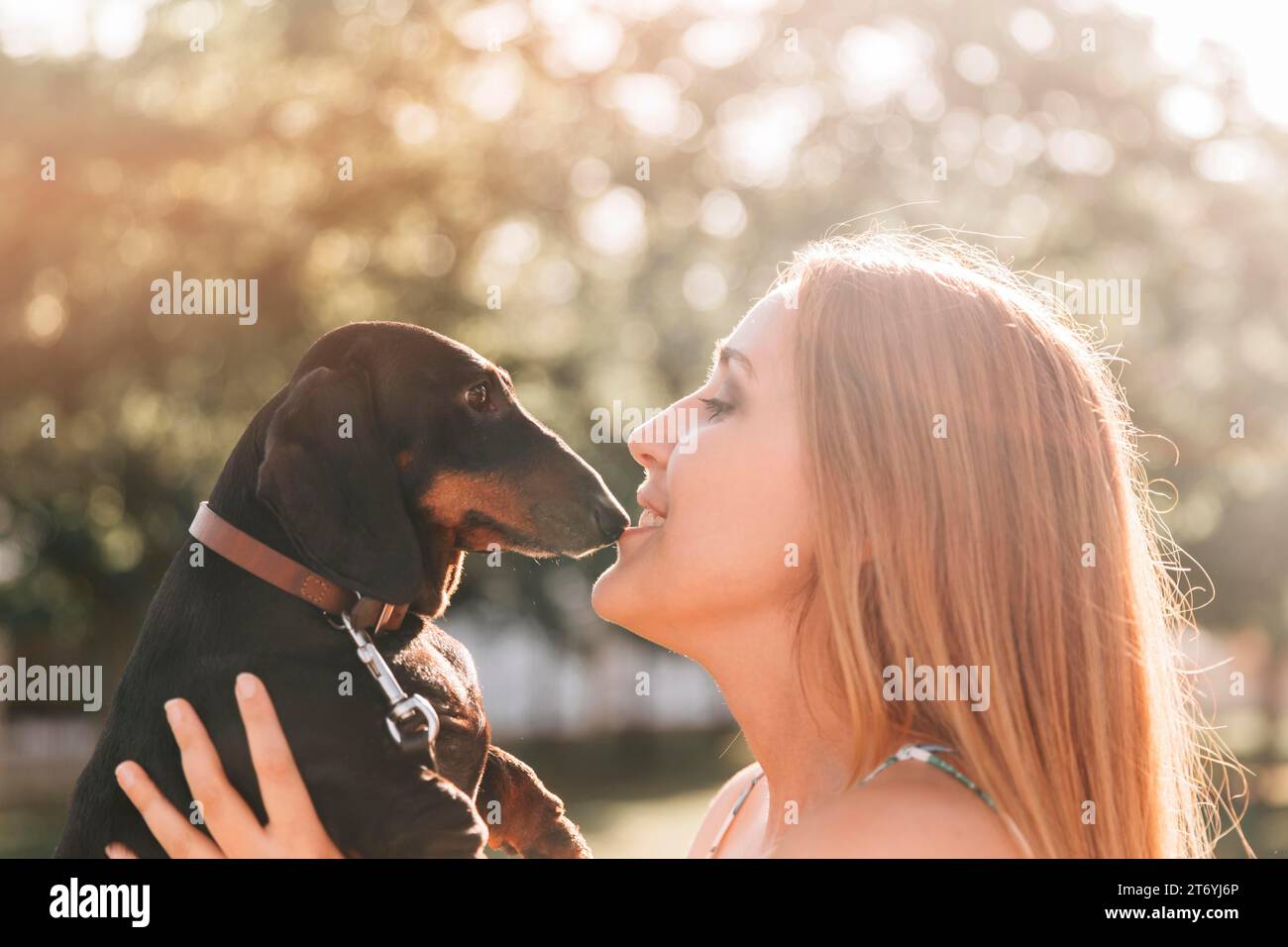 Bella donna che baciava il suo cane carino Foto Stock
