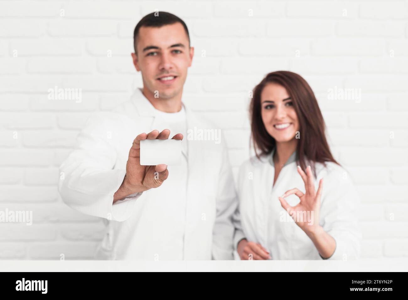 I medici sorridenti che mostrano una scheda di firma ok-up Foto Stock