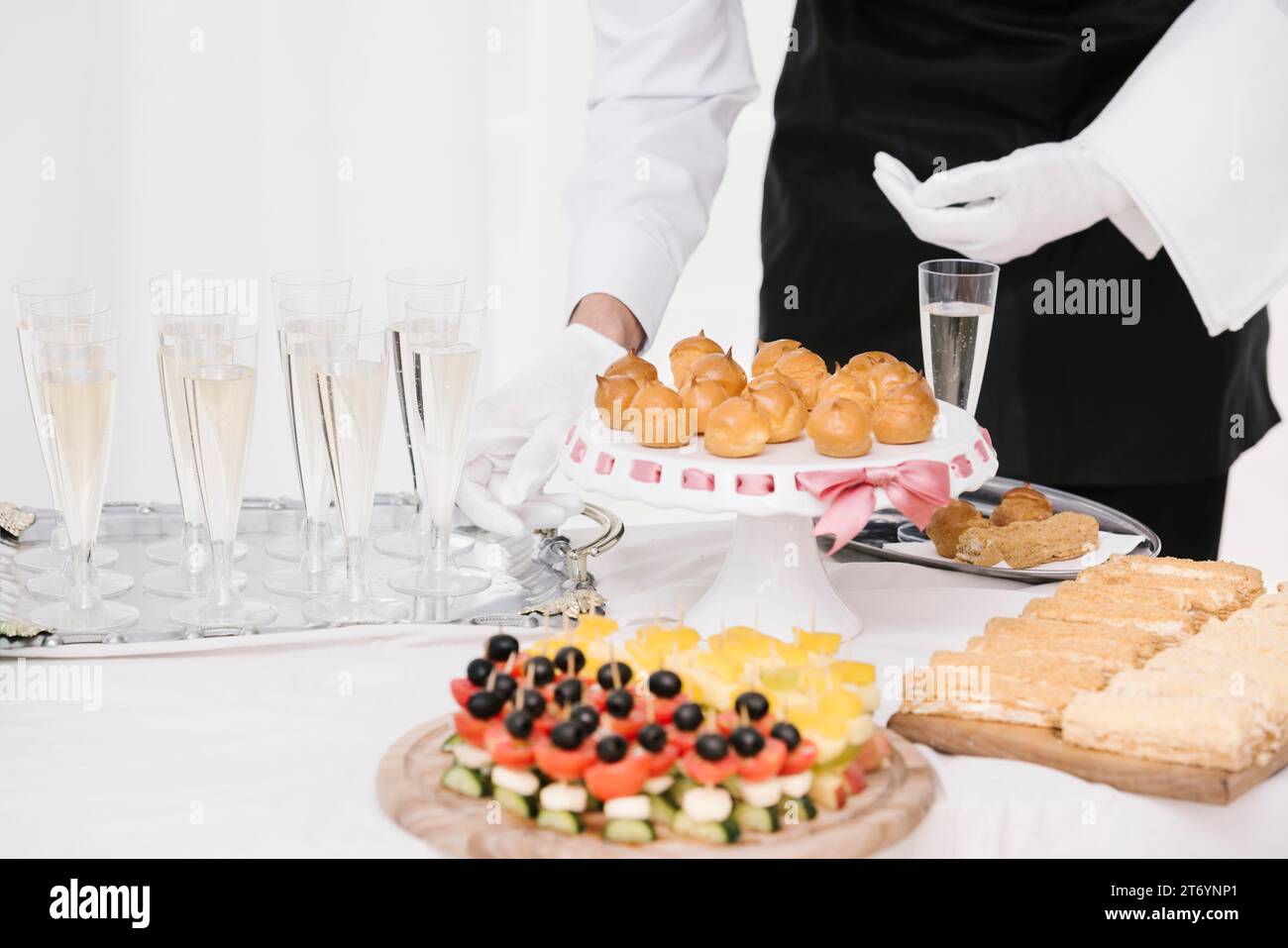 Il cameriere presenta un tavolo mix di cibi e bevande Foto Stock