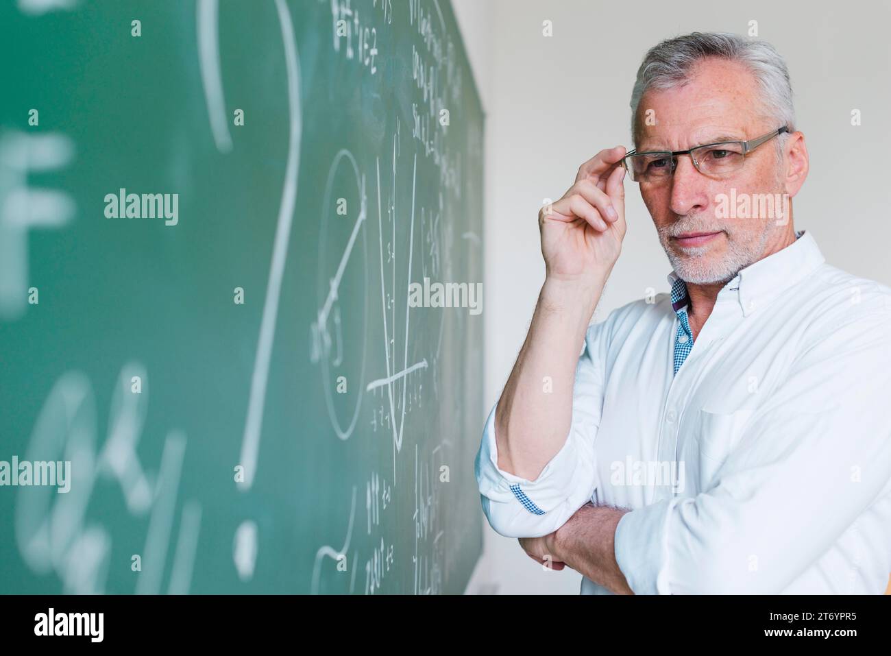 Lavagna concentrata per insegnanti di matematica invecchiati Foto Stock