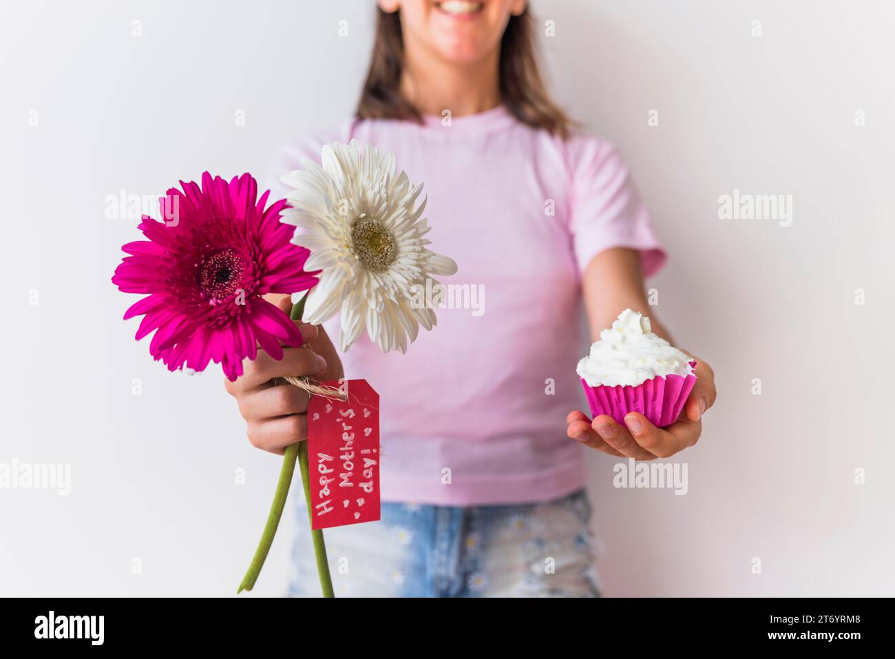 Ragazza che tiene fiori con l'iscrizione della festa della mamma felice Foto Stock