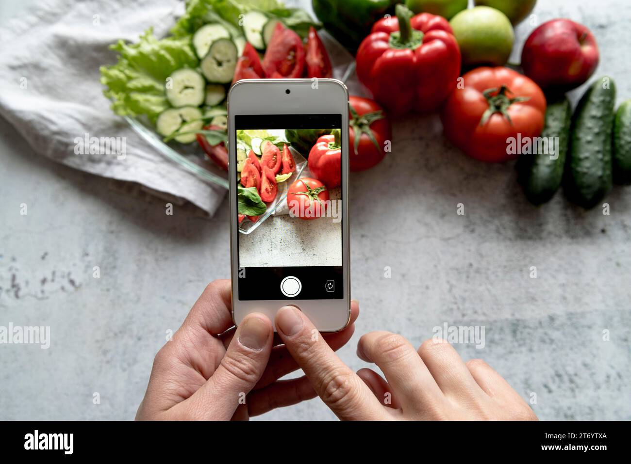 Persona che scatta foto a mano con sfondo vegetale fresco Foto Stock