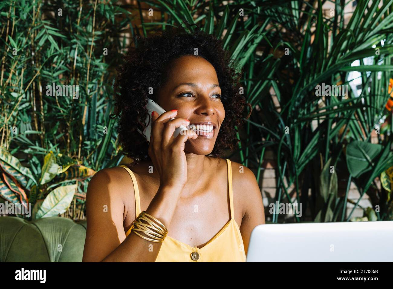 Primo piano della giovane donna sorridente che parla di un telefono cellulare Foto Stock