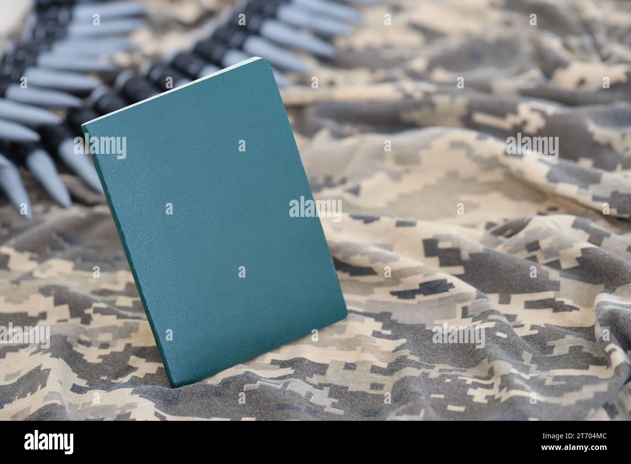 Documento d'identità militare ucraino su tessuto con trama mimetica pixeled. Panno con motivo camouflage in pixel grigio, marrone e verde con gettone personale dell'esercito ucraino e cintura di proiettili mitragliatrici Foto Stock