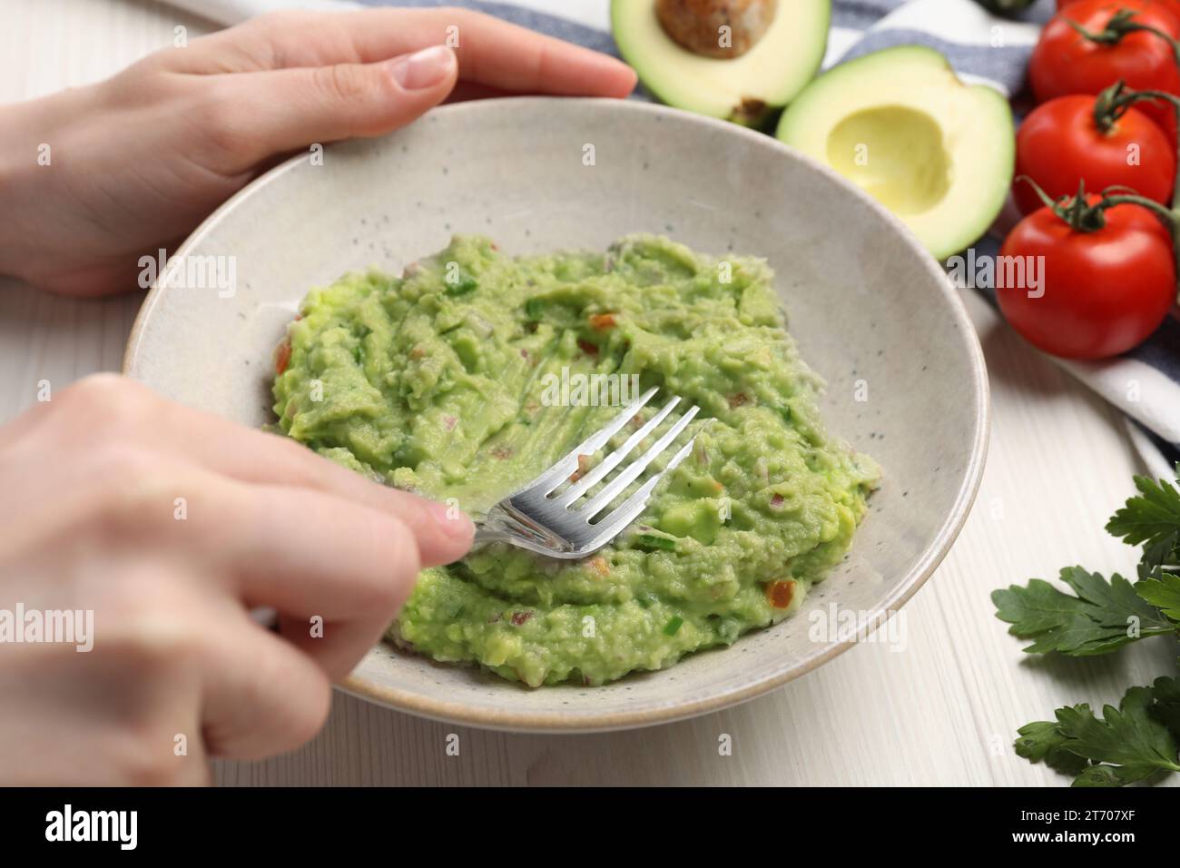 Donna che prepara delizioso guacamole al tavolo bianco, primo piano Foto Stock