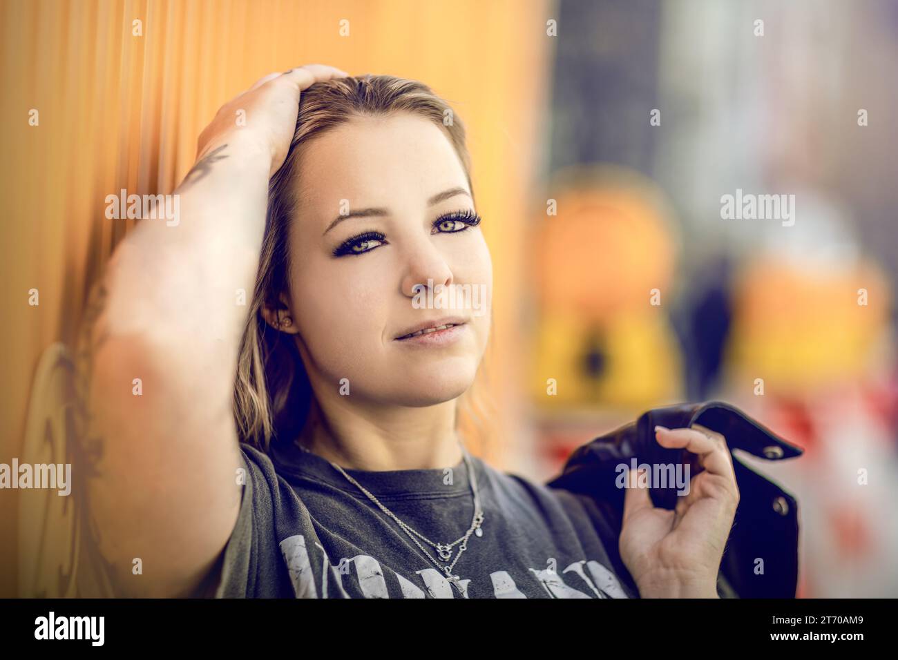 Primo piano di una giovane donna bionda che guarda sulle spalle, ritratto streetstyle Foto Stock