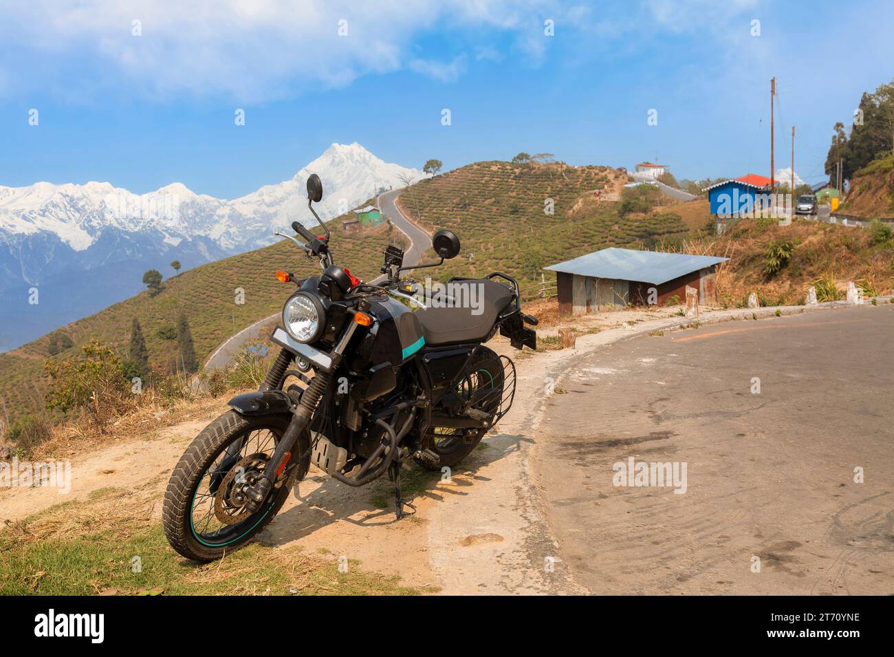 Bici da turismo parcheggiata sul lato di una strada con vista della catena montuosa dell'Himalaya Kanchenjunga vicino a Tinchuley, Darjeeling, India Foto Stock