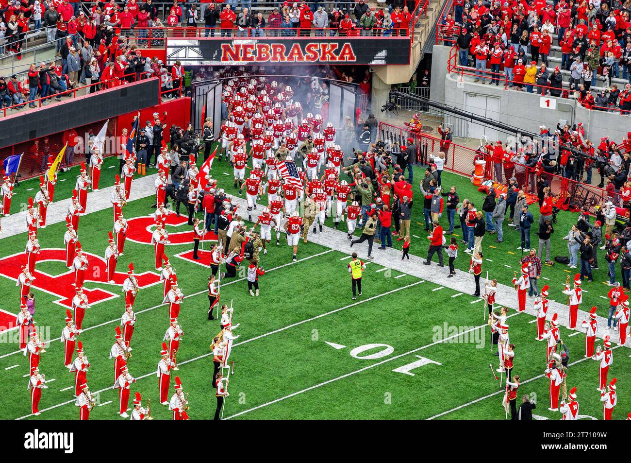 11 novembre 2023 - Lincoln, Nebraska. Stati Uniti - Nebraska Cornhuskers entrano nel Tom Osborne Field mostrando una bandiera americana prima di una partita di football NCAA Division 1 tra Maryland Terrapins e Nebraska Cornhuskers al Memorial Stadium di Lincoln, Nebraska..Maryland ha vinto 13-10.presenze: 86.830.395esimo sellout consecutivo.Michael Spomer/Cal Sport Media Foto Stock