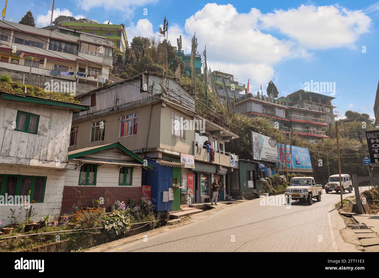 Darjeeling City Road con binari giocattolo, negozi e turisti. Darjeeling è una popolare stazione collinare nello stato del Bengala Occidentale, in India. Foto Stock