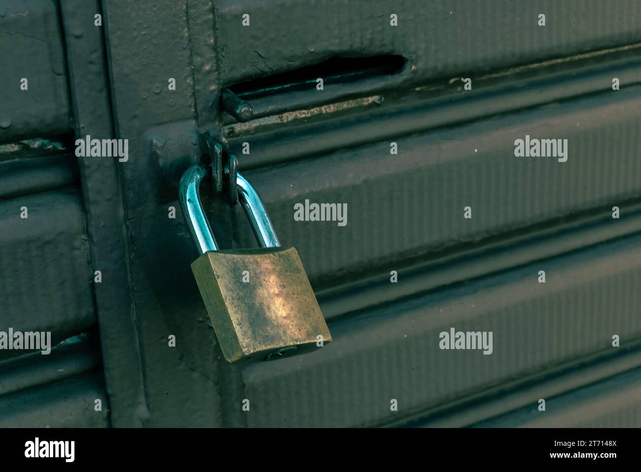 Lucchetto chiuso appeso al cancello di metallo verde in Brasile Foto Stock