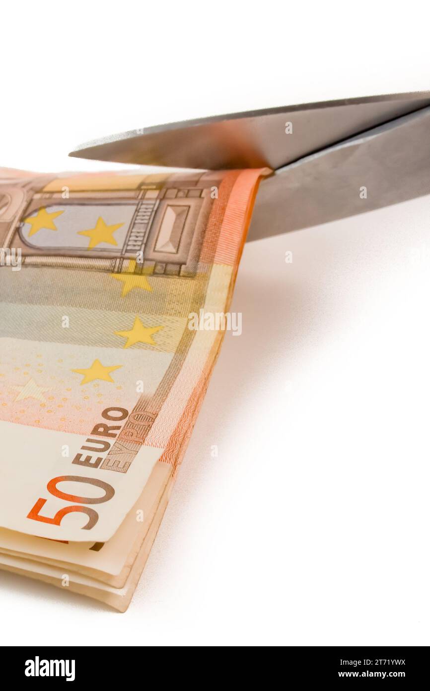 dettaglio delle banconote in euro usate e delle forbici su sfondo bianco Foto Stock