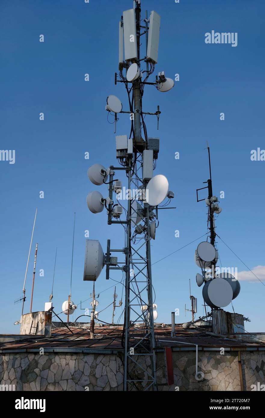 Antenna di telecomunicazione con più parabole satellitari contro il cielo blu Foto Stock