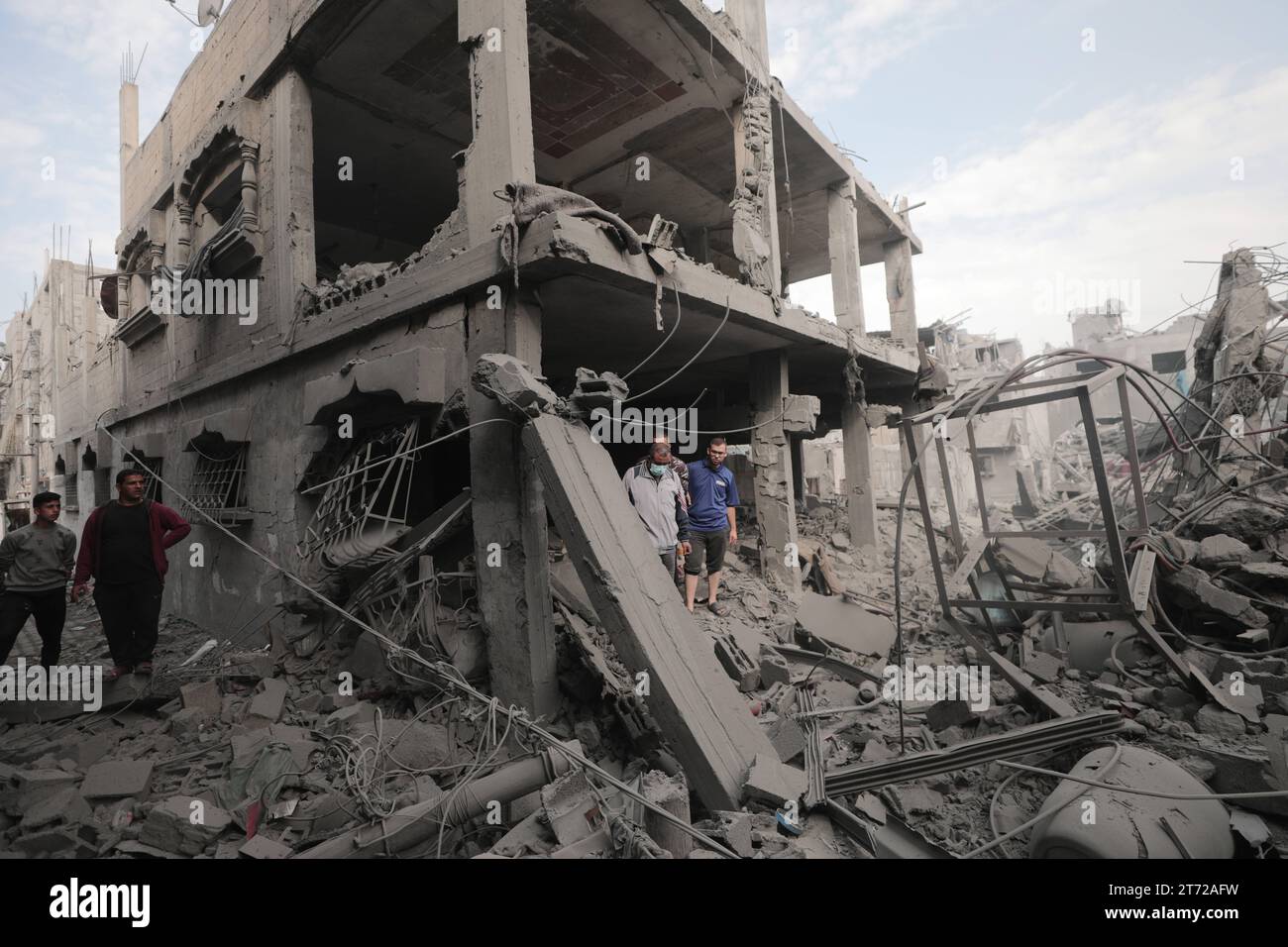 I palestinesi ispezionano la casa distrutta della famiglia Ghanem, a seguito di un attacco aereo israeliano sul campo profughi di Bureij i palestinesi ispezionano la casa distrutta della famiglia Ghanem, a seguito di un attacco aereo israeliano sul campo profughi di Bureij, nel centro della Striscia di Gaza, il 13 novembre 2023. Israele sta affrontando forti pressioni internazionali per ridurre al minimo le sofferenze civili in un'operazione aerea e terrestre di massa che le autorità di Hamas affermano abbia già ucciso più di 11.000 persone, tra cui migliaia di bambini. La campagna militare è arrivata dopo che i combattenti di Hamas hanno attraversato il confine militarizzato con Israele a ottobre Foto Stock