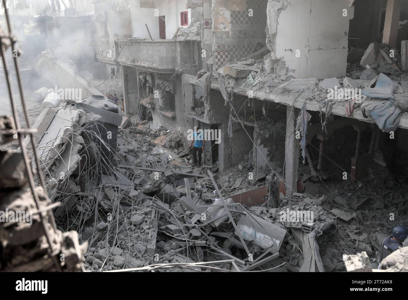 I palestinesi ispezionano la casa distrutta della famiglia Ghanem, a seguito di un attacco aereo israeliano sul campo profughi di Bureij i palestinesi ispezionano la casa distrutta della famiglia Ghanem, a seguito di un attacco aereo israeliano sul campo profughi di Bureij, nel centro della Striscia di Gaza, il 13 novembre 2023. Israele sta affrontando forti pressioni internazionali per ridurre al minimo le sofferenze civili in un'operazione aerea e terrestre di massa che le autorità di Hamas affermano abbia già ucciso più di 11.000 persone, tra cui migliaia di bambini. La campagna militare è arrivata dopo che i combattenti di Hamas hanno attraversato il confine militarizzato con Israele a ottobre Foto Stock