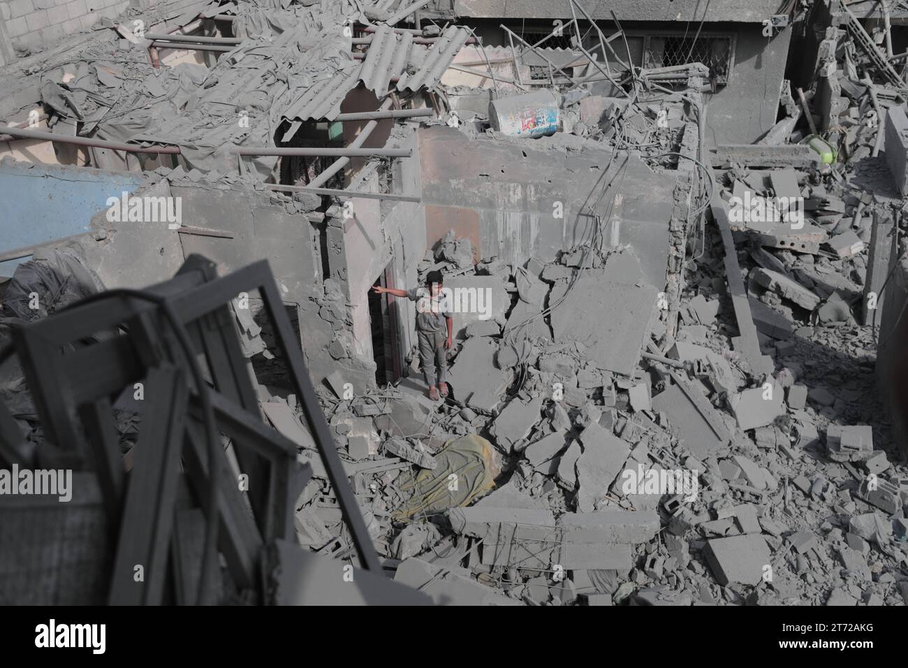 I palestinesi ispezionano la casa distrutta della famiglia Ghanem, a seguito di un attacco aereo israeliano sul campo profughi di Bureij i palestinesi ispezionano la casa distrutta della famiglia Ghanem, a seguito di un attacco aereo israeliano sul campo profughi di Bureij, nel centro della Striscia di Gaza, il 13 novembre 2023. Israele sta affrontando forti pressioni internazionali per ridurre al minimo le sofferenze civili in un'operazione aerea e terrestre di massa che le autorità di Hamas affermano abbia già ucciso più di 11.000 persone, tra cui migliaia di bambini. La campagna militare è arrivata dopo che i combattenti di Hamas hanno attraversato il confine militarizzato con Israele a ottobre Foto Stock