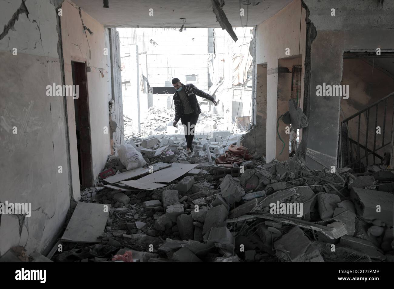 I palestinesi ispezionano la casa distrutta della famiglia Ghanem, a seguito di un attacco aereo israeliano sul campo profughi di Bureij i palestinesi ispezionano la casa distrutta della famiglia Ghanem, a seguito di un attacco aereo israeliano sul campo profughi di Bureij, nel centro della Striscia di Gaza, il 13 novembre 2023. Israele sta affrontando forti pressioni internazionali per ridurre al minimo le sofferenze civili in un'operazione aerea e terrestre di massa che le autorità di Hamas affermano abbia già ucciso più di 11.000 persone, tra cui migliaia di bambini. La campagna militare è arrivata dopo che i combattenti di Hamas hanno attraversato il confine militarizzato con Israele a ottobre Foto Stock