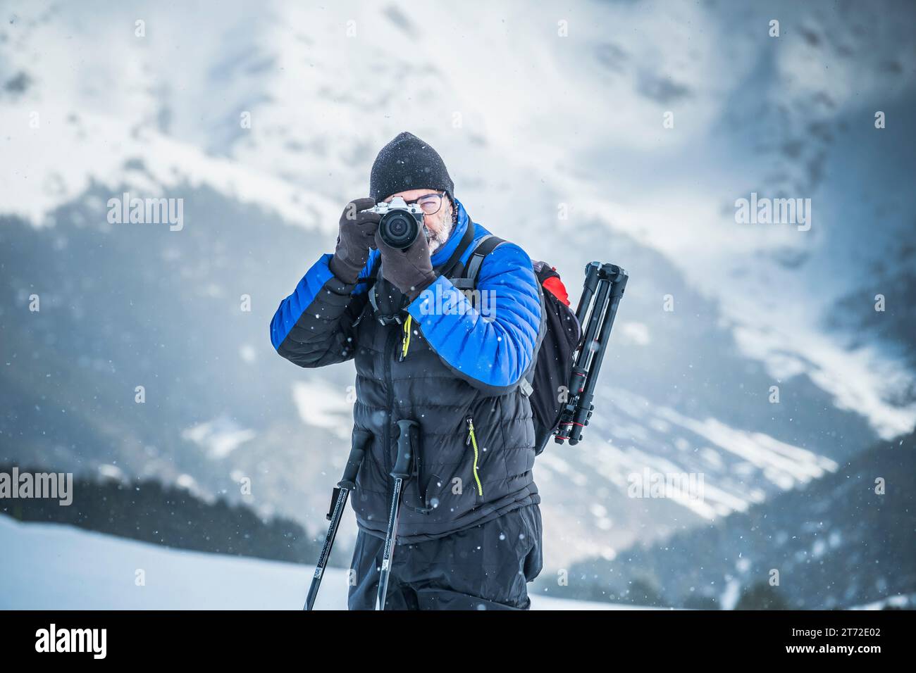 Uomo che scatta una foto in una nevicata Foto Stock