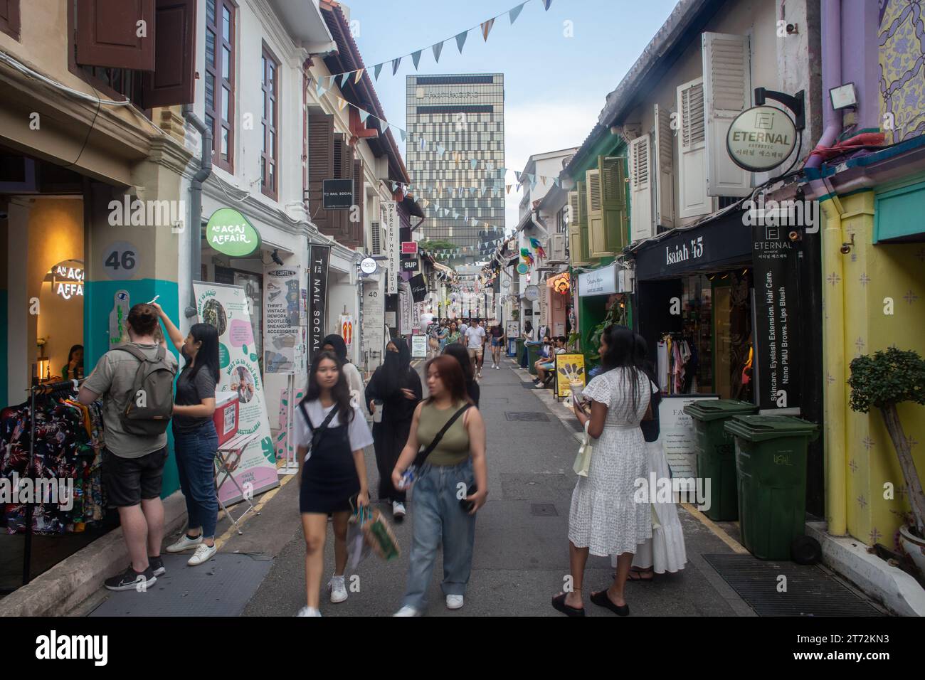 Multi-etnico e diverse donne che visitano e fanno shopping a Haji Lane, una popolare strada culturale di Singapore. Composizione simmetrica. Foto Stock
