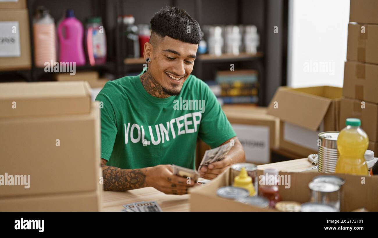 Un giovane latinoamericano sicuro di sé si offre volontario, sorridendo contando i dollari al centro di beneficenza, facendo la differenza Foto Stock