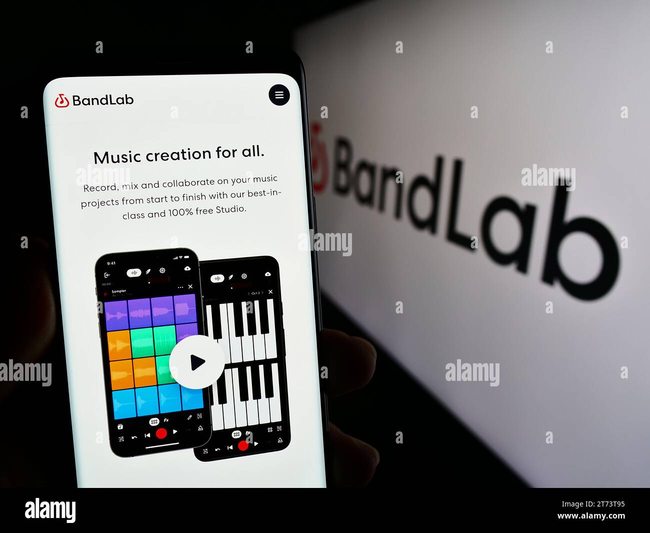 Persona che possiede uno smartphone con una pagina Web della società musicale di Singapore BandLab Technologies davanti al logo. Concentrarsi sul centro del display del telefono. Foto Stock