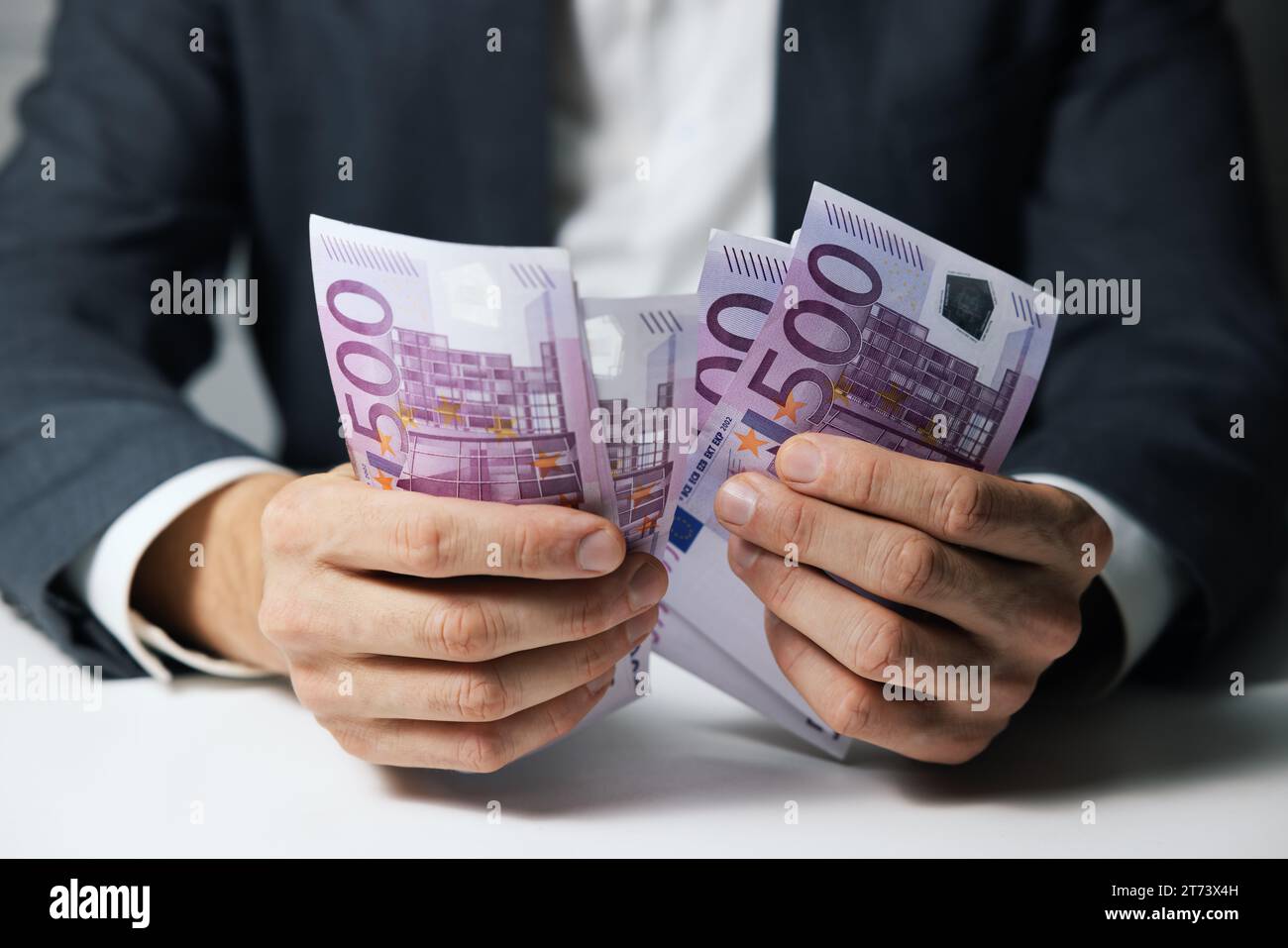 primo piano delle mani di un uomo d’affari che contano 500 banconote in euro Foto Stock