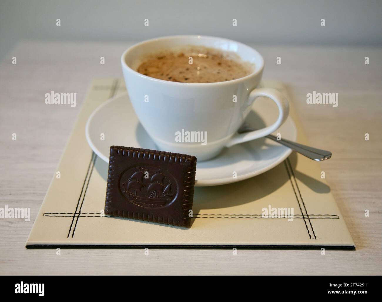 Una tazza di caffè caldo e un biscotto al cioccolato Foto Stock