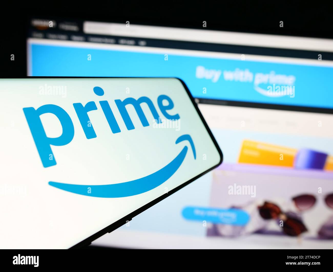 Smartphone con logo del servizio di abbonamento Amazon prime davanti al sito Web dell'azienda. Mettere a fuoco il display centrale sinistro del telefono. Foto Stock
