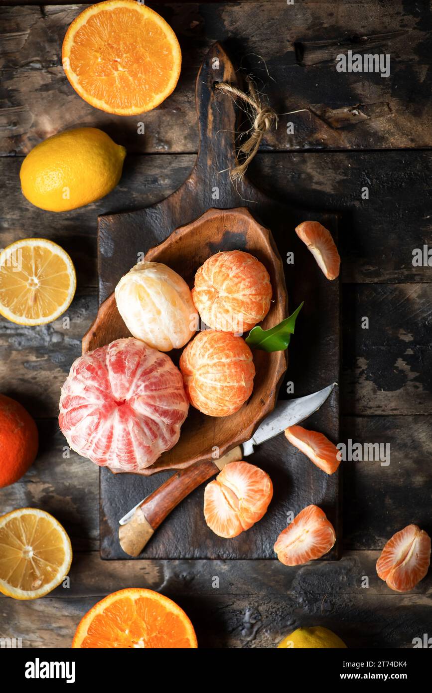 Mandarino fresco, arancia, limone e pompelmo in una ciotola su un tavolo di legno. Vista dall'alto Foto Stock