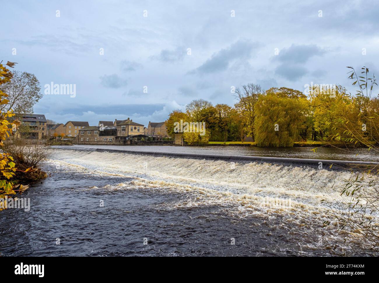 Weir sul River Wharfe a Otley, con il ristorante Buon Apps in lontananza, visto in autunno. REGNO UNITO Foto Stock