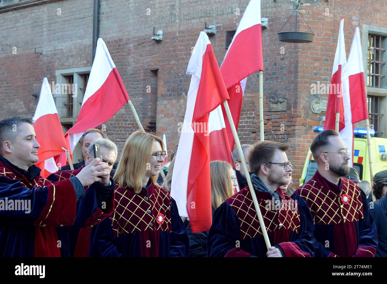 DANZICA, POLONIA - 11 NOVEMBRE 2023: :Sfilata dei manifestanti con le bandiere polacche giù Ulica Długa per il giorno dell'indipendenza polacca nella città vecchia. Foto Stock