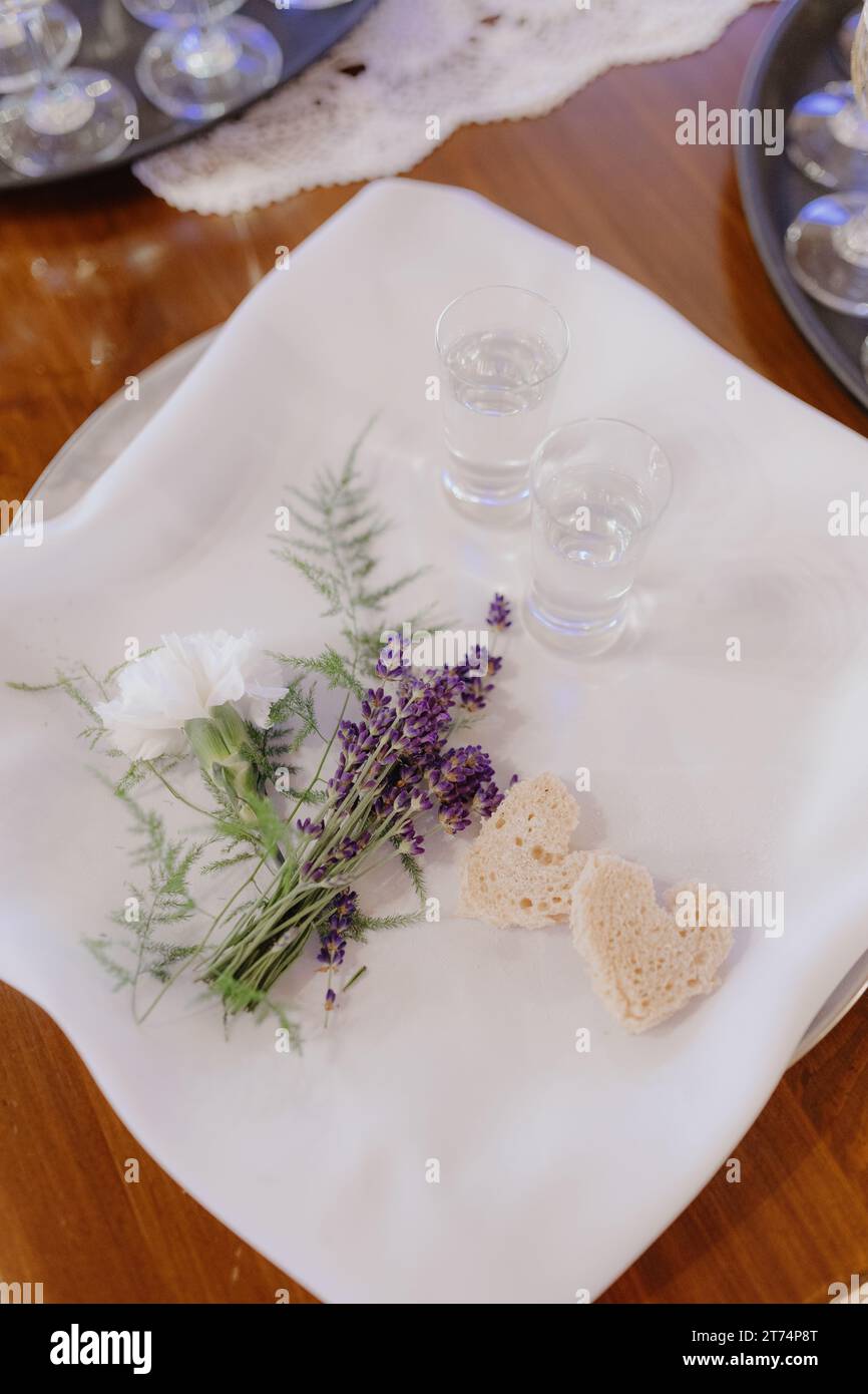 Tema del matrimonio. Bicchieri di cristallo con alcool, dolci sono posti su tovagliolo di lino bianco-neve. Foto Stock