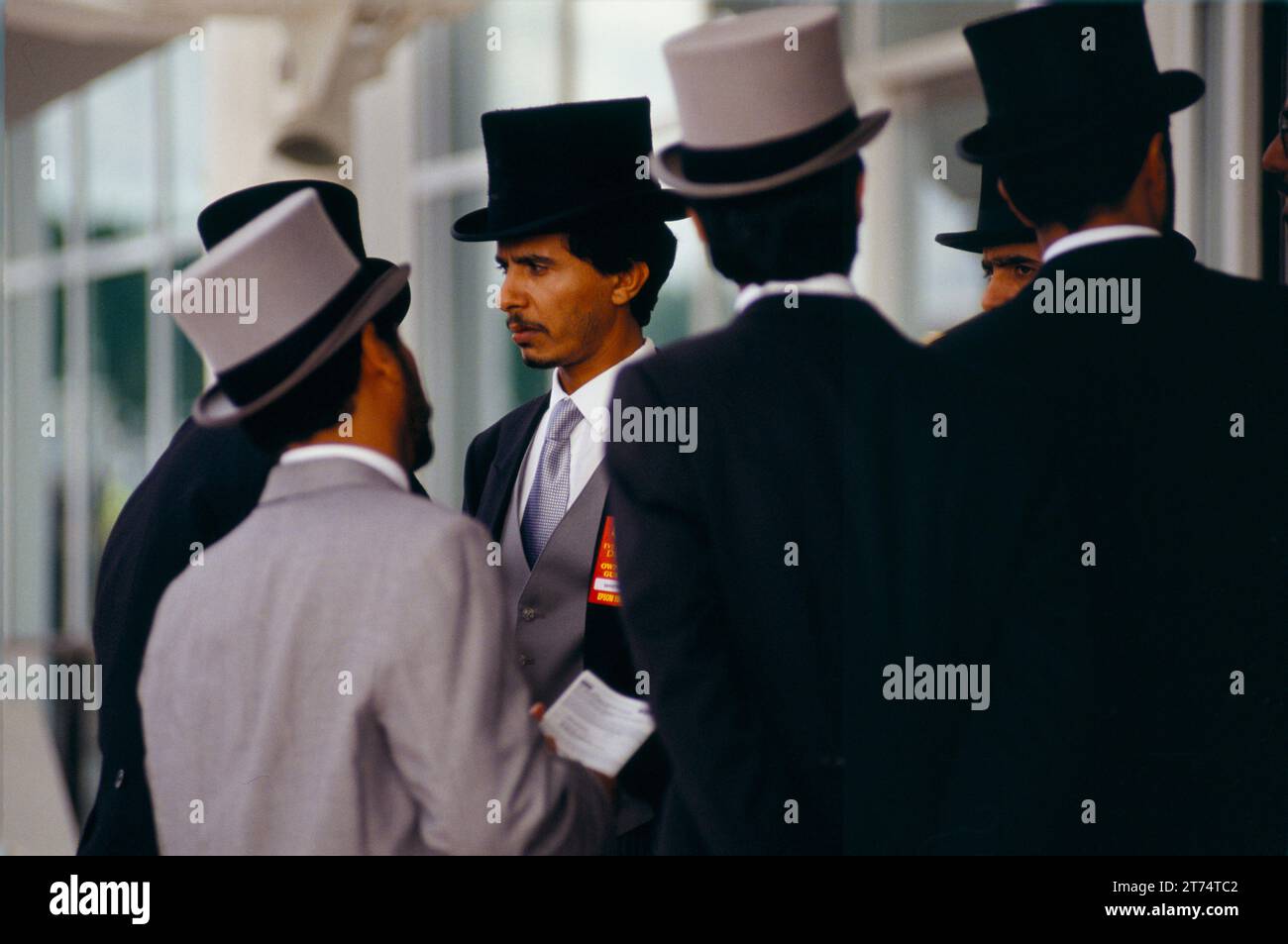 Uomini arabi in abiti occidentali, cappotti a coda e cappello che fanno tutti parte dell'entourage dello sceicco Mohammed al Maktoum al Royal Ascot, nel Members Enclosure. Berkshire, Inghilterra, circa giugno 1983. 1980S UK HOMER SYKES Foto Stock