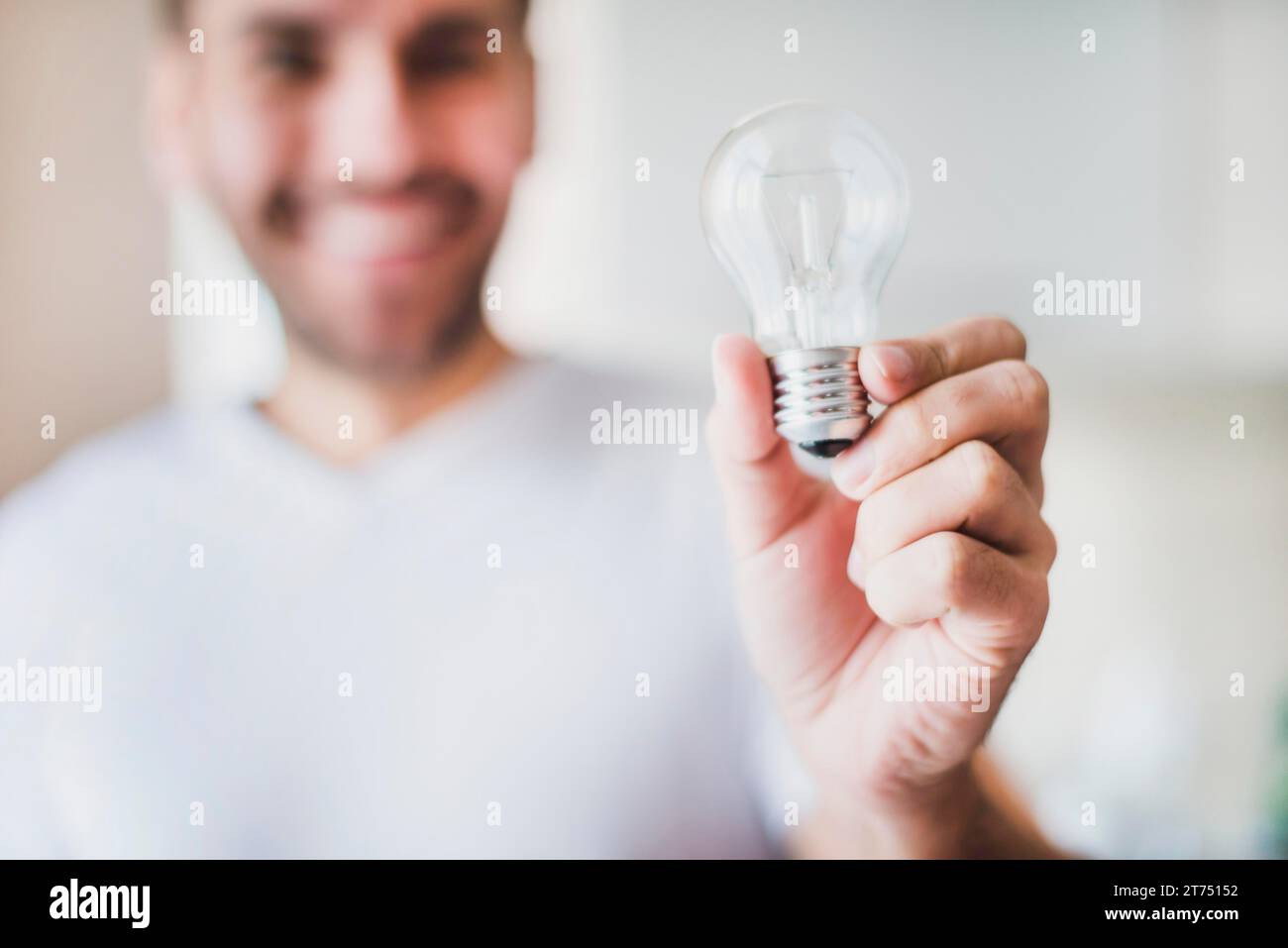 Sfoca uomo che mostra una lampadina trasparente Foto Stock
