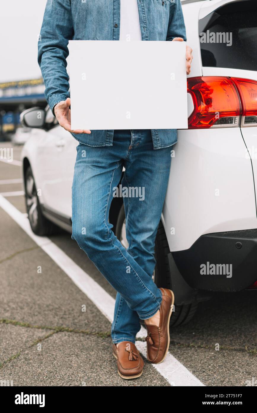 Uomo da vicino alla strada che mostra un cartello bianco vuoto Foto Stock