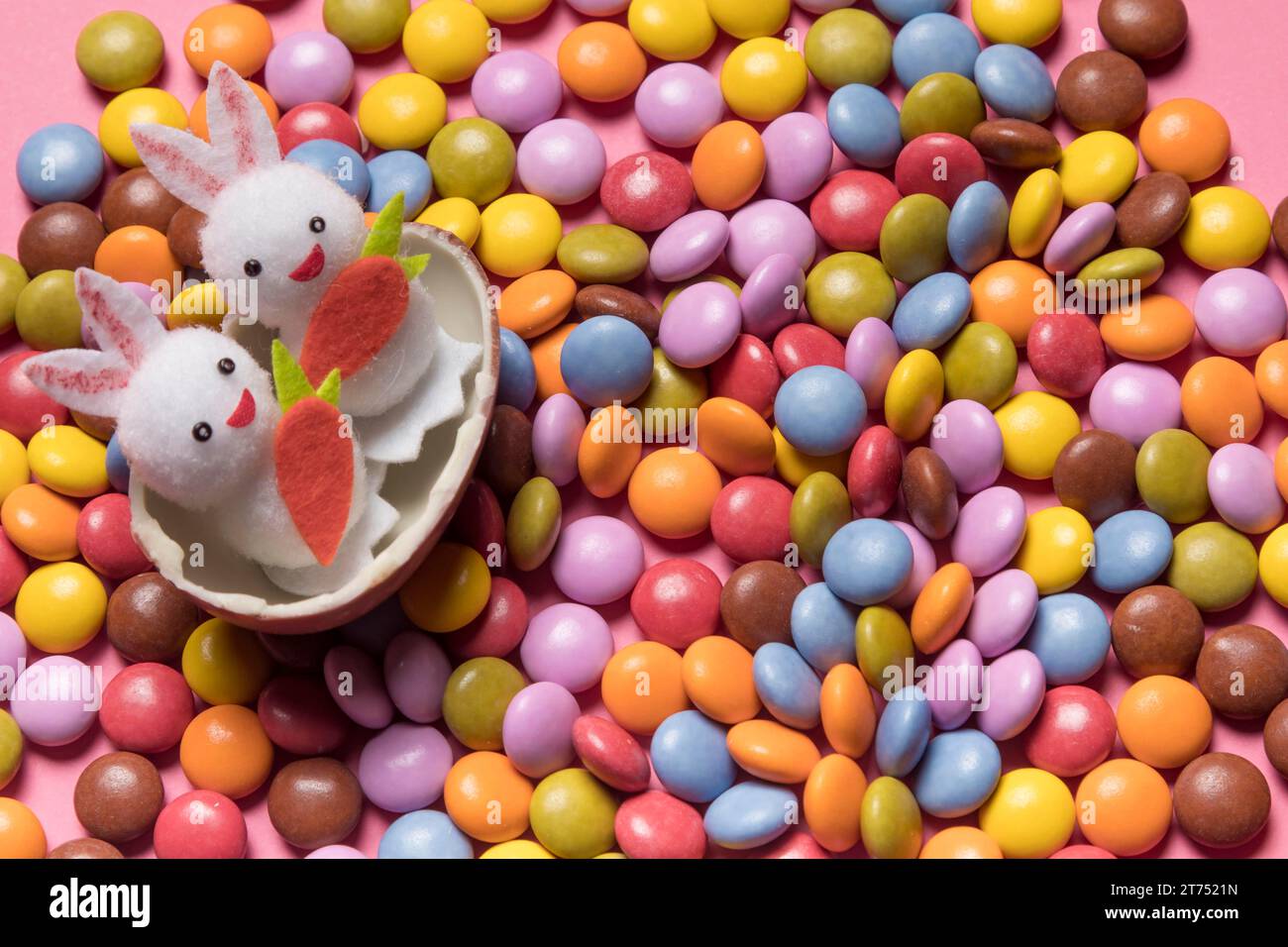 Carini due coniglietti all'interno di caramelle colorate con l'uovo di pasqua rotto Foto Stock