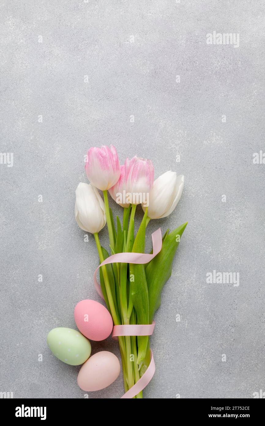 Adagiate dei bellissimi tulipani con il nastro delle uova di pasqua colorate Foto Stock