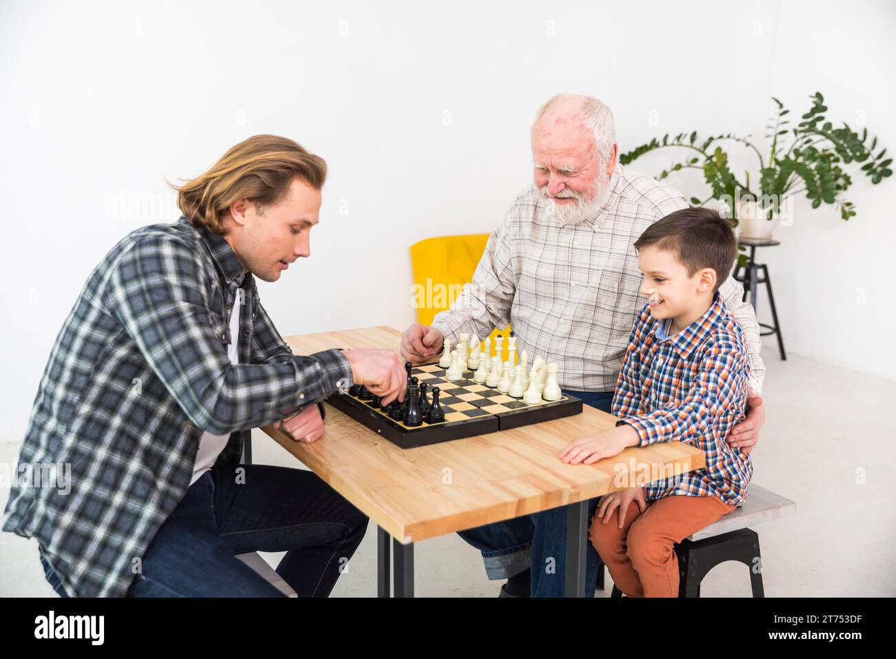 Uomini multigenerazionali che giocano a scacchi Foto Stock
