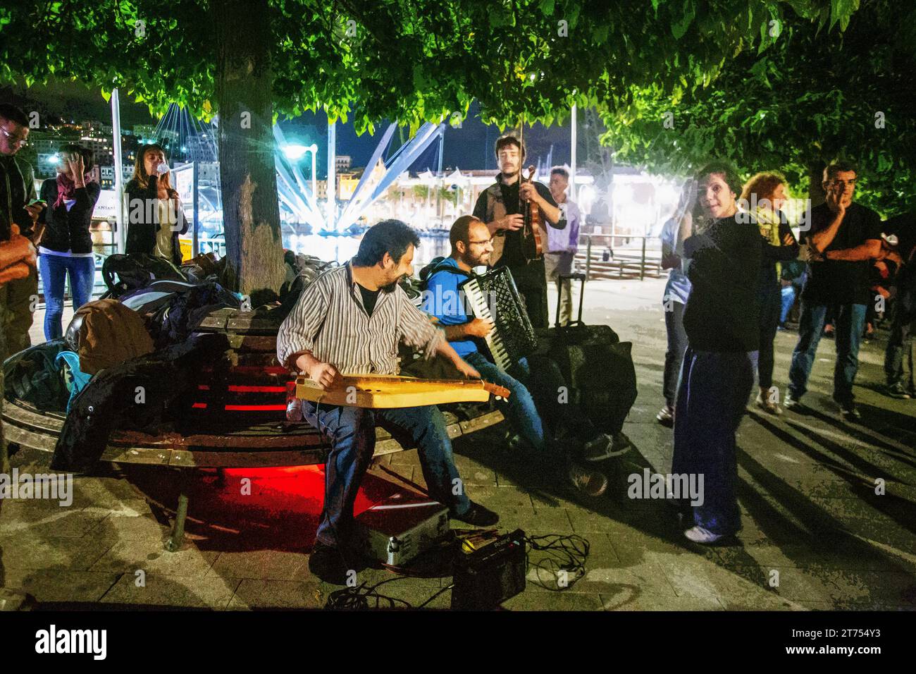 22-09-2015 Genova, Italia musicisti - (fisarmonica e altro) in festa all'aperto diverse coppie danzanti a Genova . Dietro le luci del porto di Genova in Foto Stock