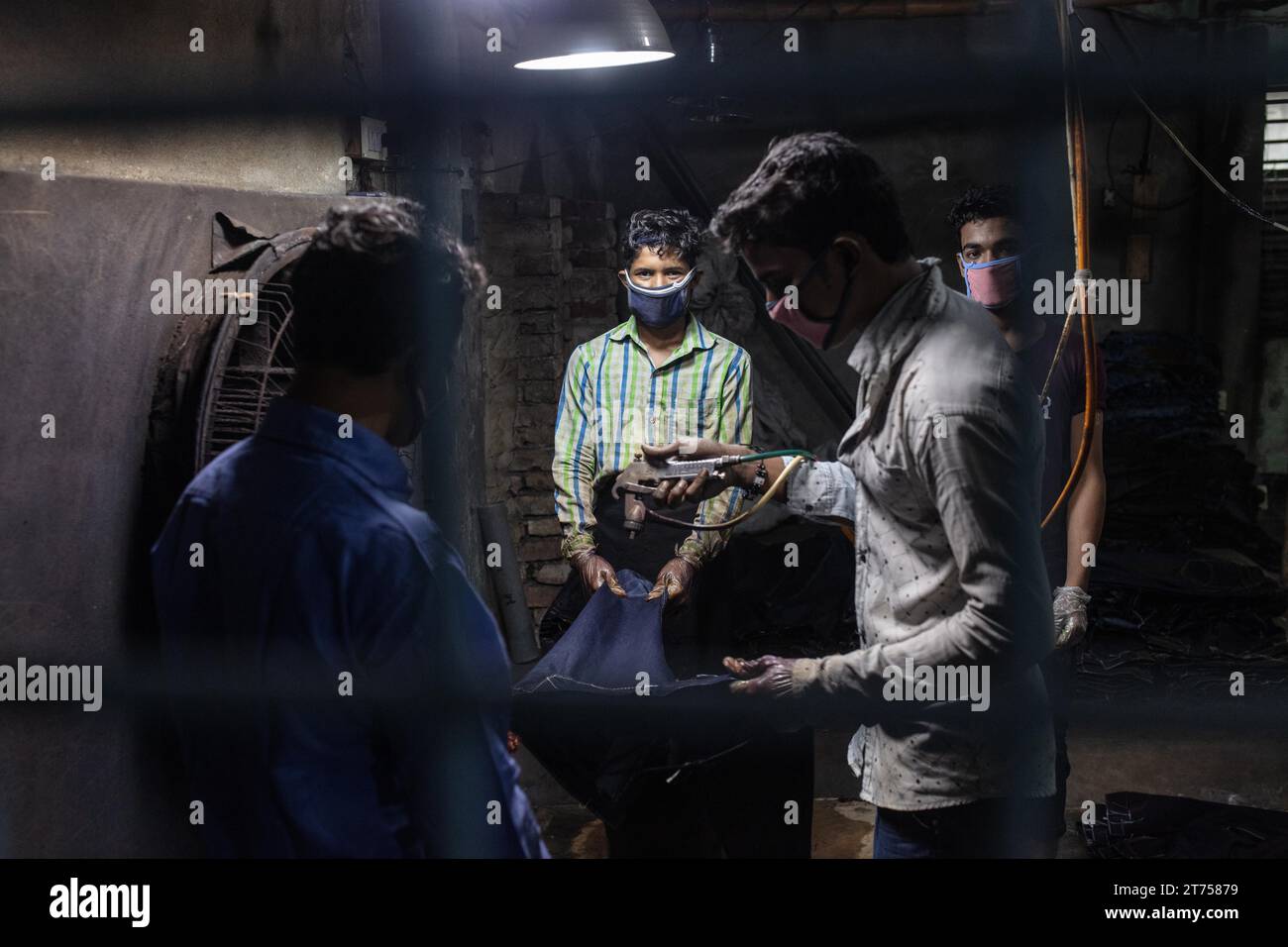 Lavoratori che colorano jeans in una fabbrica tessile, Dacca, Bangladesh Foto Stock