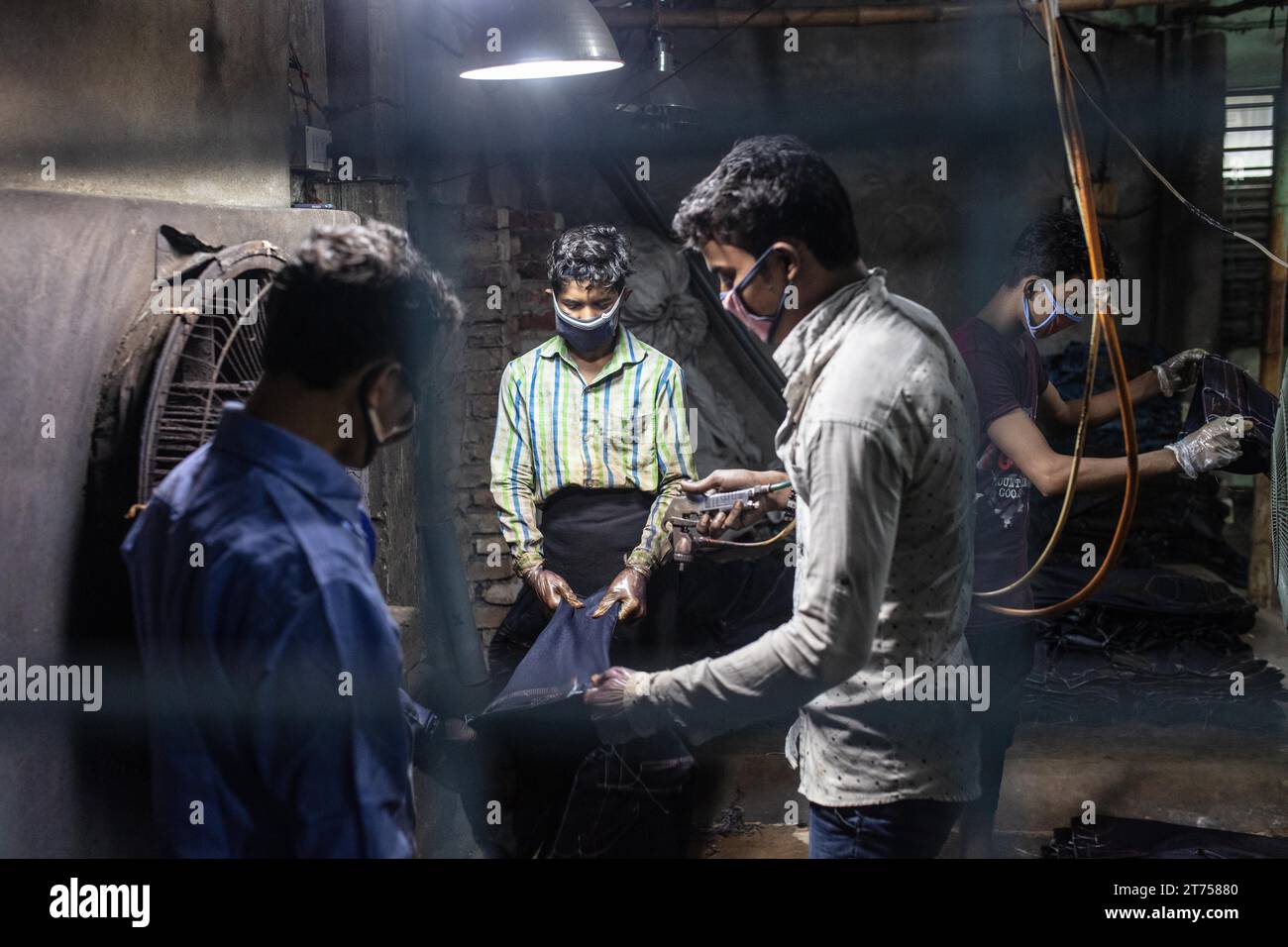 Lavoratori che colorano jeans in una fabbrica tessile, Dacca, Bangladesh Foto Stock